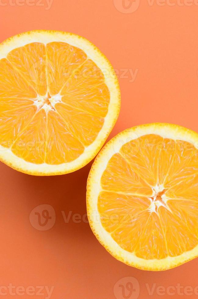 Top view of a several orange fruit slices on bright background in orange color. A saturated citrus texture image photo