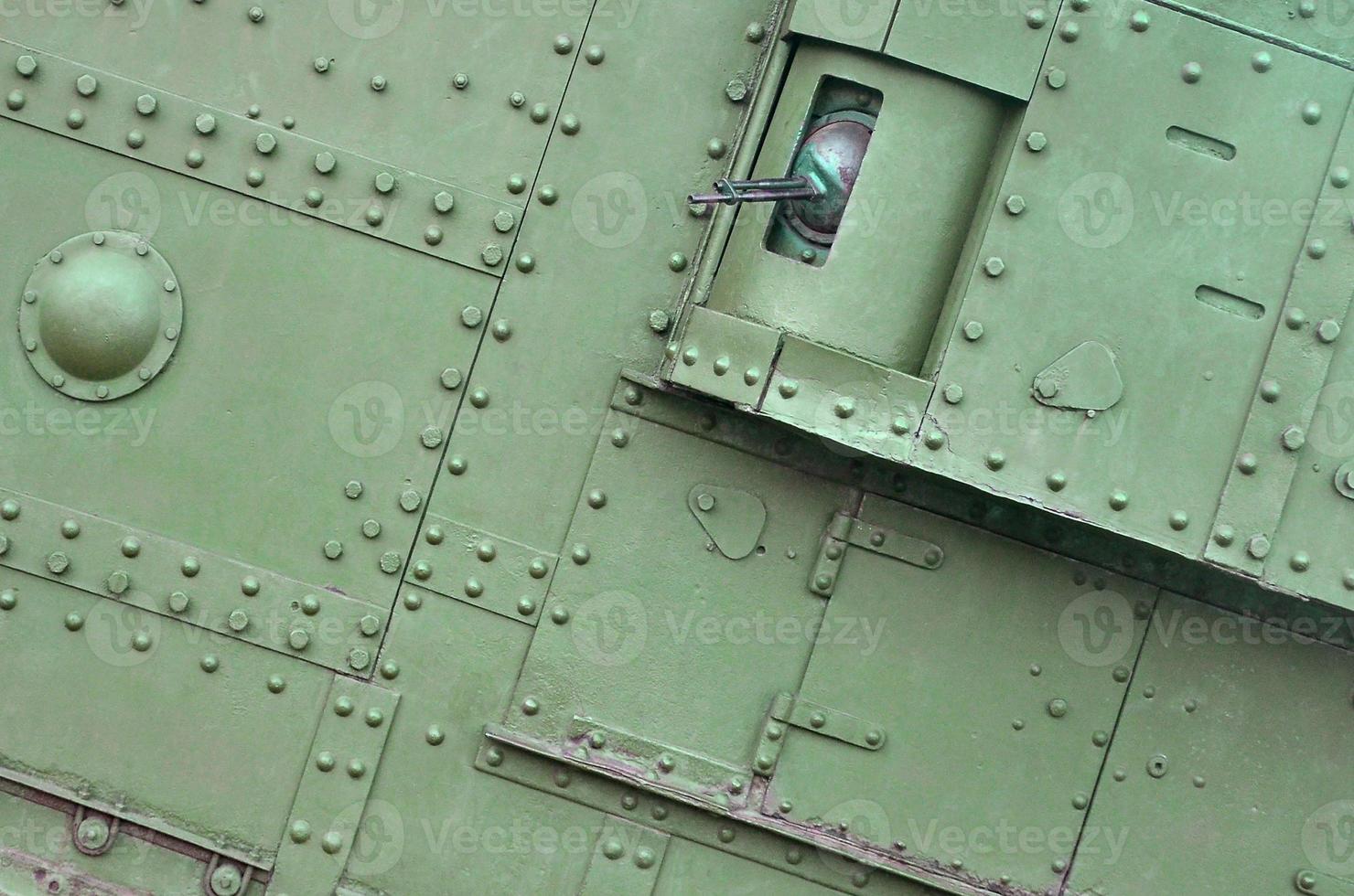 Texture of tank side wall, made of metal and reinforced with a multitude of bolts and rivets photo