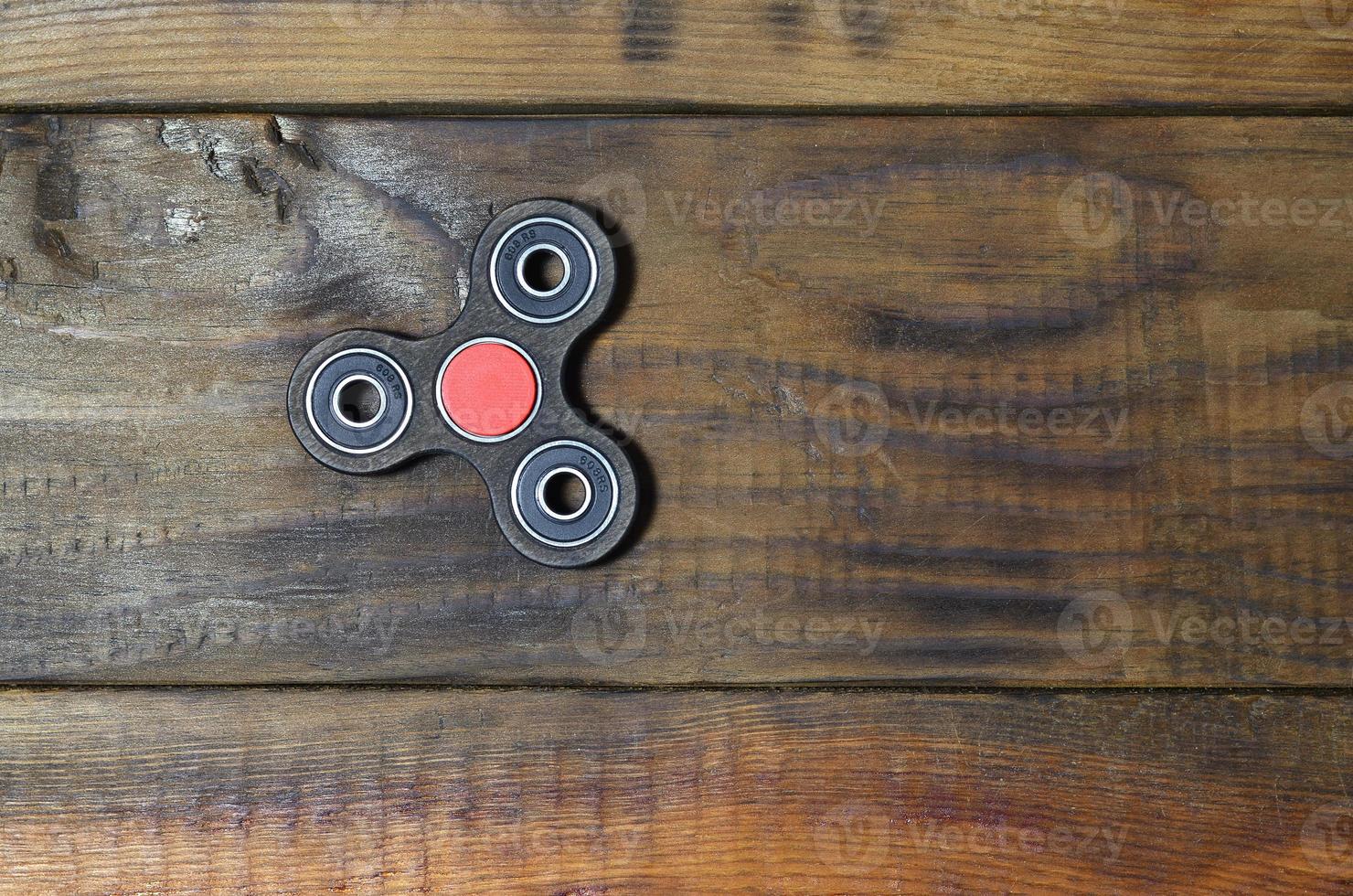 Popular finger spinner device. Modern fidget spinning toy on bearings. Spin it in hands learn cool new tricks. Have fun with this new rotating gadget photo
