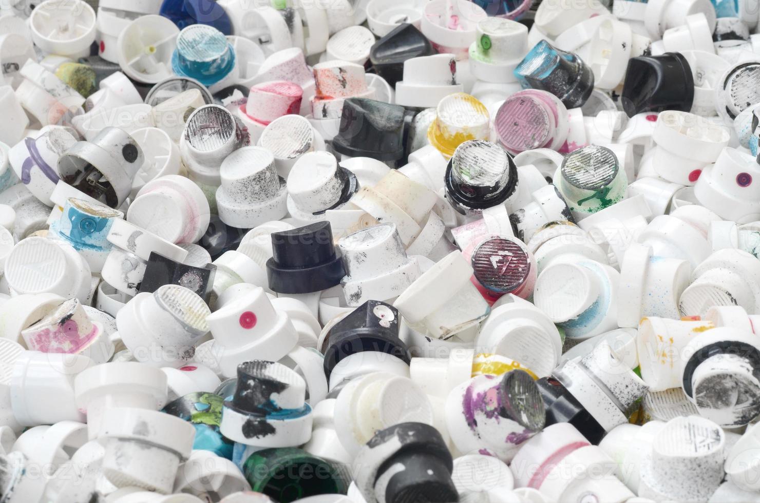 A pattern of many used and soiled nozzles from spray cans with aerosol paint. Background texture of the street art of drawing graffiti on the walls photo