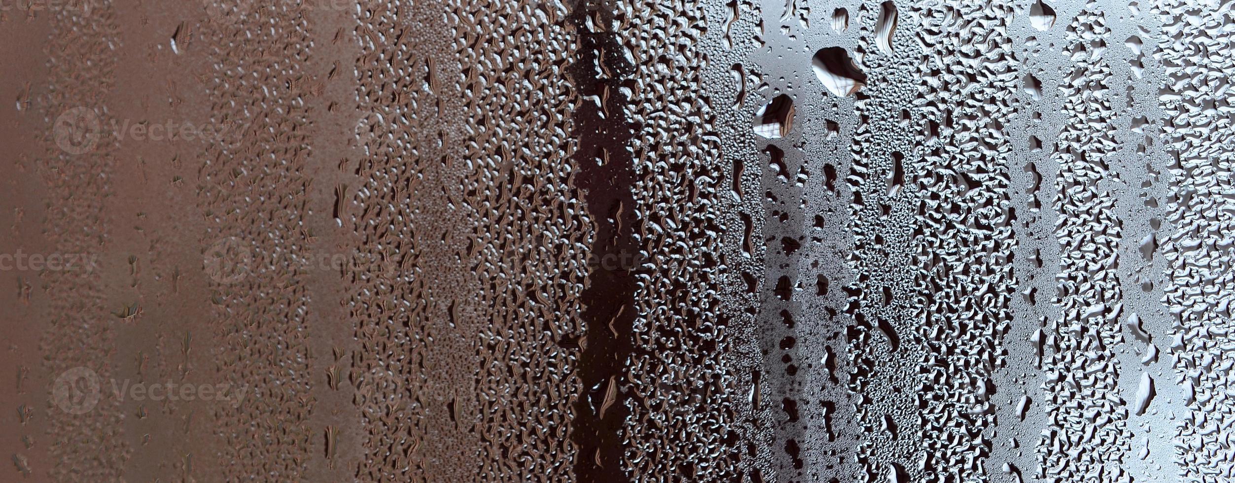 Texture of a drop of rain on a glass wet transparent background. Toned in grey color photo