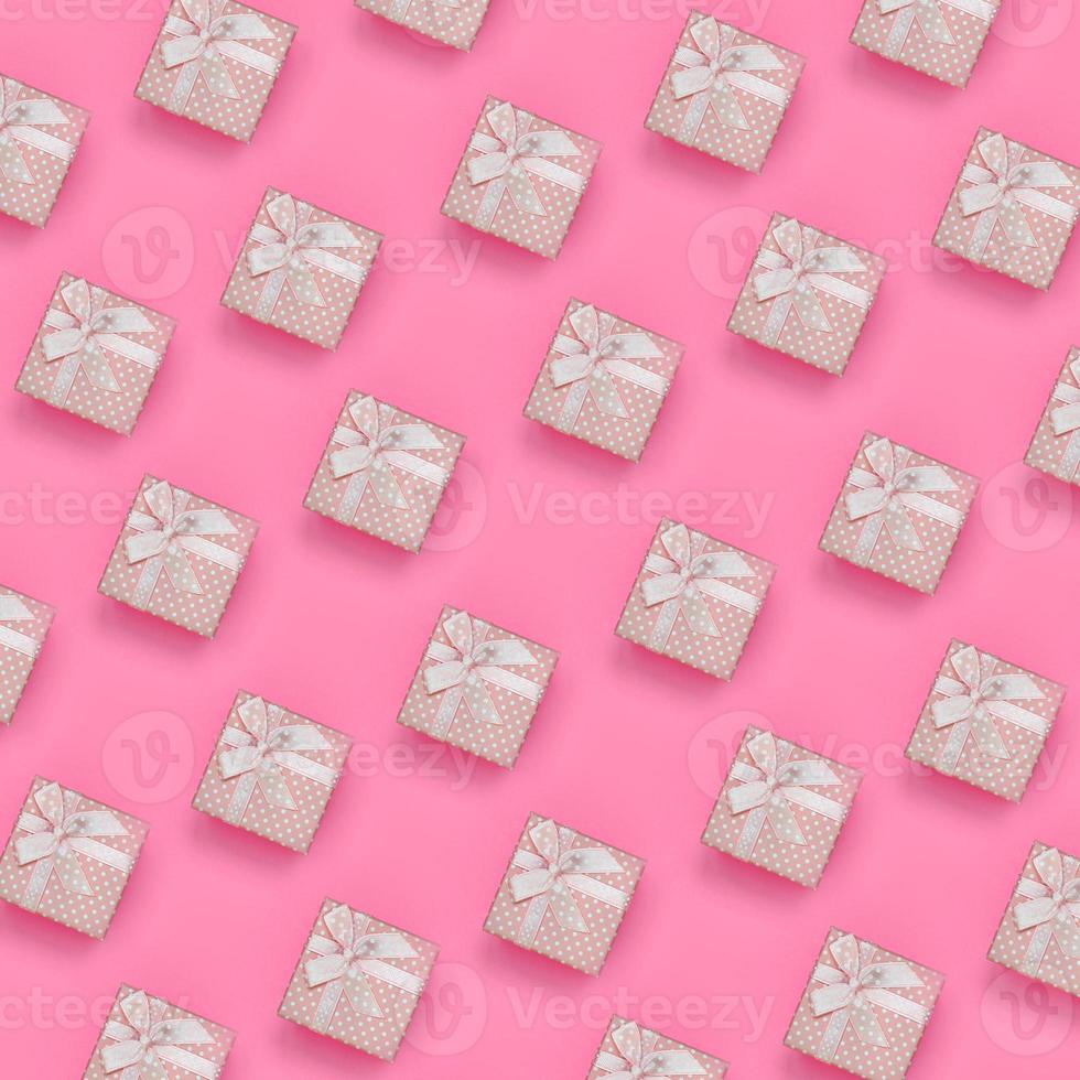 A lot of pink gift boxes lies on texture background of fashion pastel pink color paper in minimal concept. Abstract trendy pattern photo