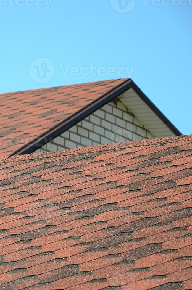 The roof is covered with bituminous shingles of brown color. Quality Roofing photo