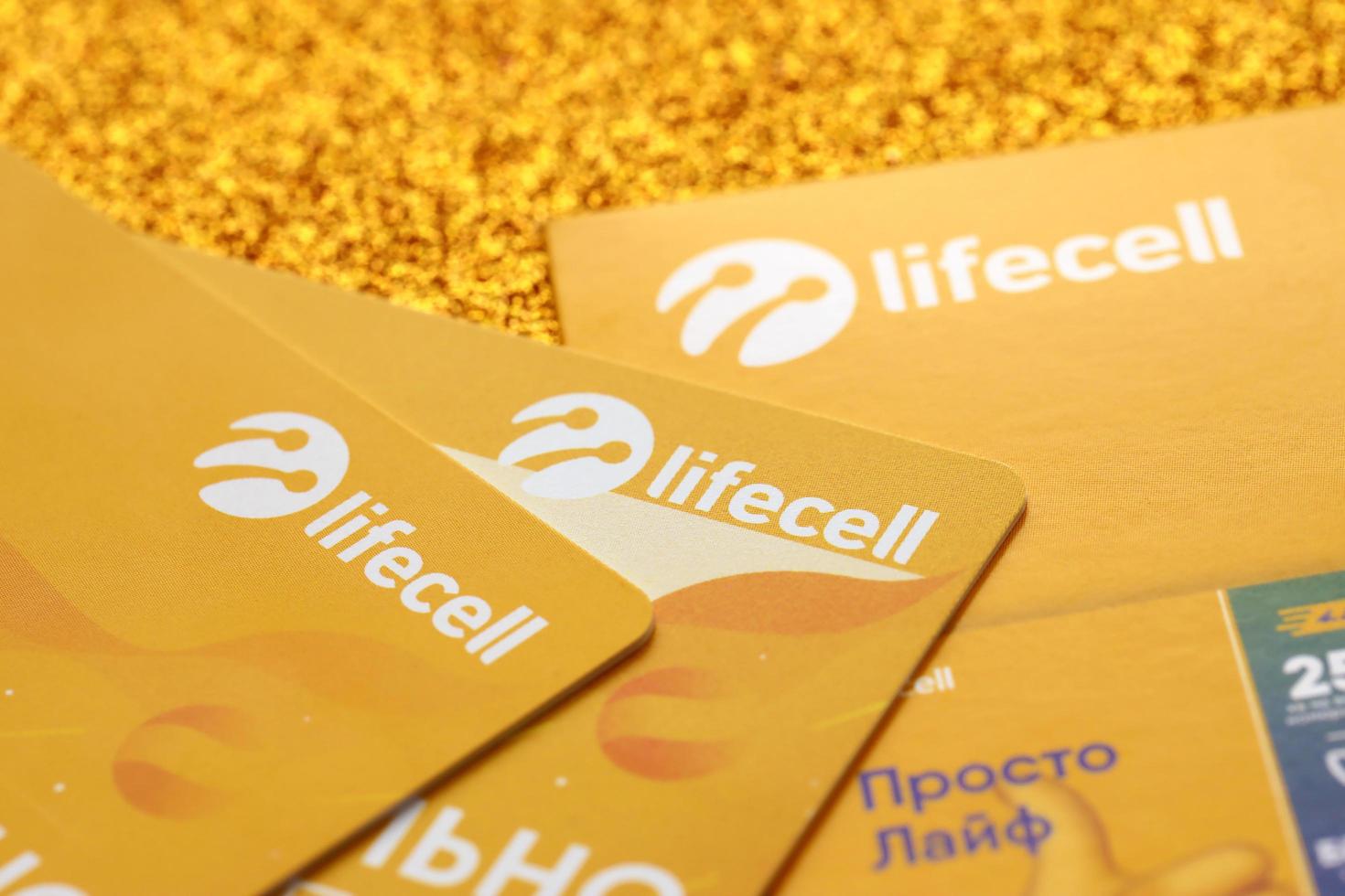 TERNOPIL, UKRAINE - JULY 5, 2022 Lifecell new sim card with free contract on yellow background. Lifecell is ukrainian mobile telephone network operator and provider of wireless connection photo