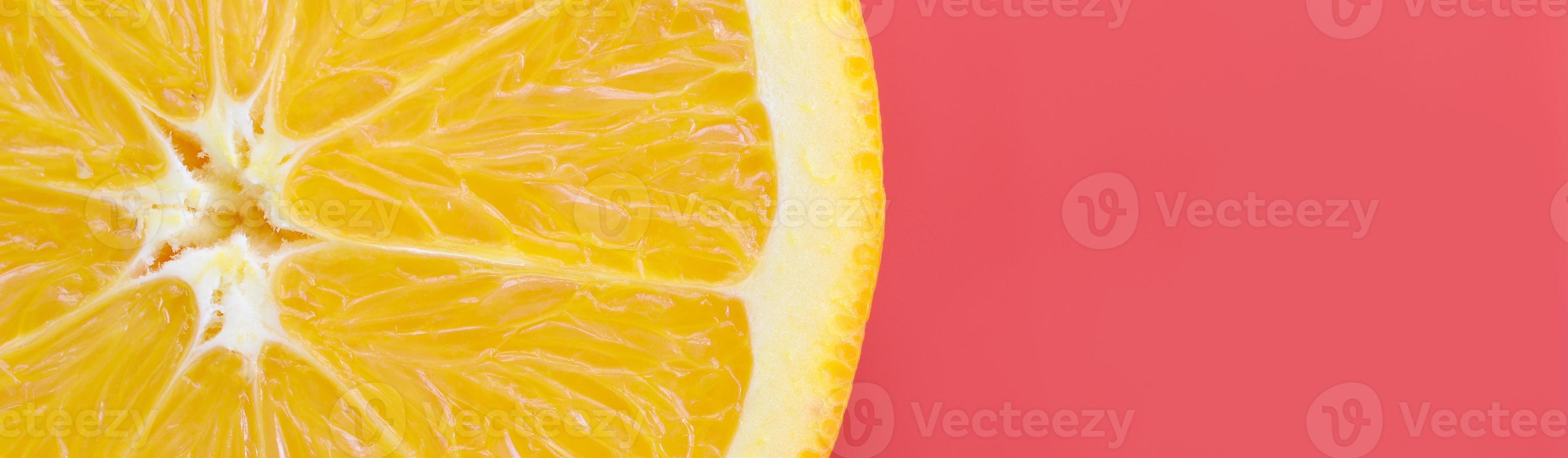 Top view of a one orange fruit slice on bright background in red color. A saturated citrus texture image photo
