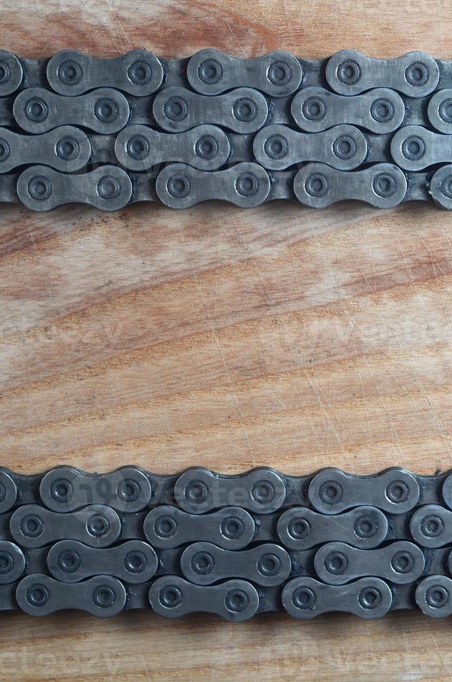 cadena sucia y aceitosa de una bicicleta de montaña sobre una mesa de madera en una tienda de bicicletas foto