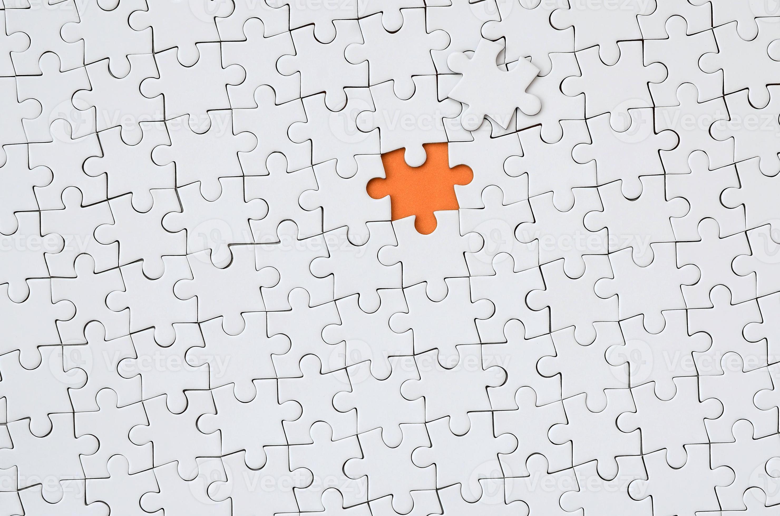 A puzzle is missing two pieces to be completed in different colors. white  pieces and one piece in green and one in orange to add text Stock Photo -  Alamy