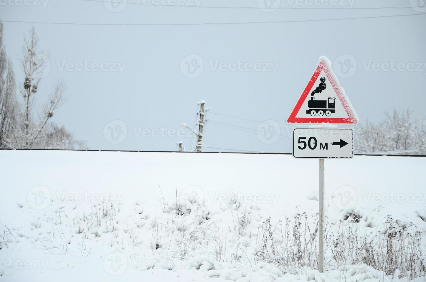 Railway crossing without barrier. A road sign depicting an old black locomotive, located in a red triangle photo