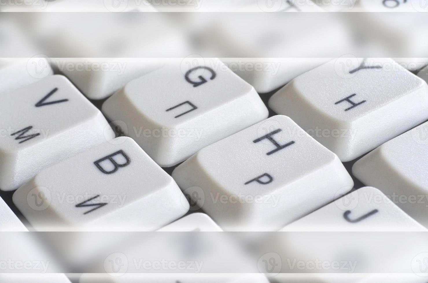 Close-up of the white computer classic keyboard with english and russian letters with copy space field photo