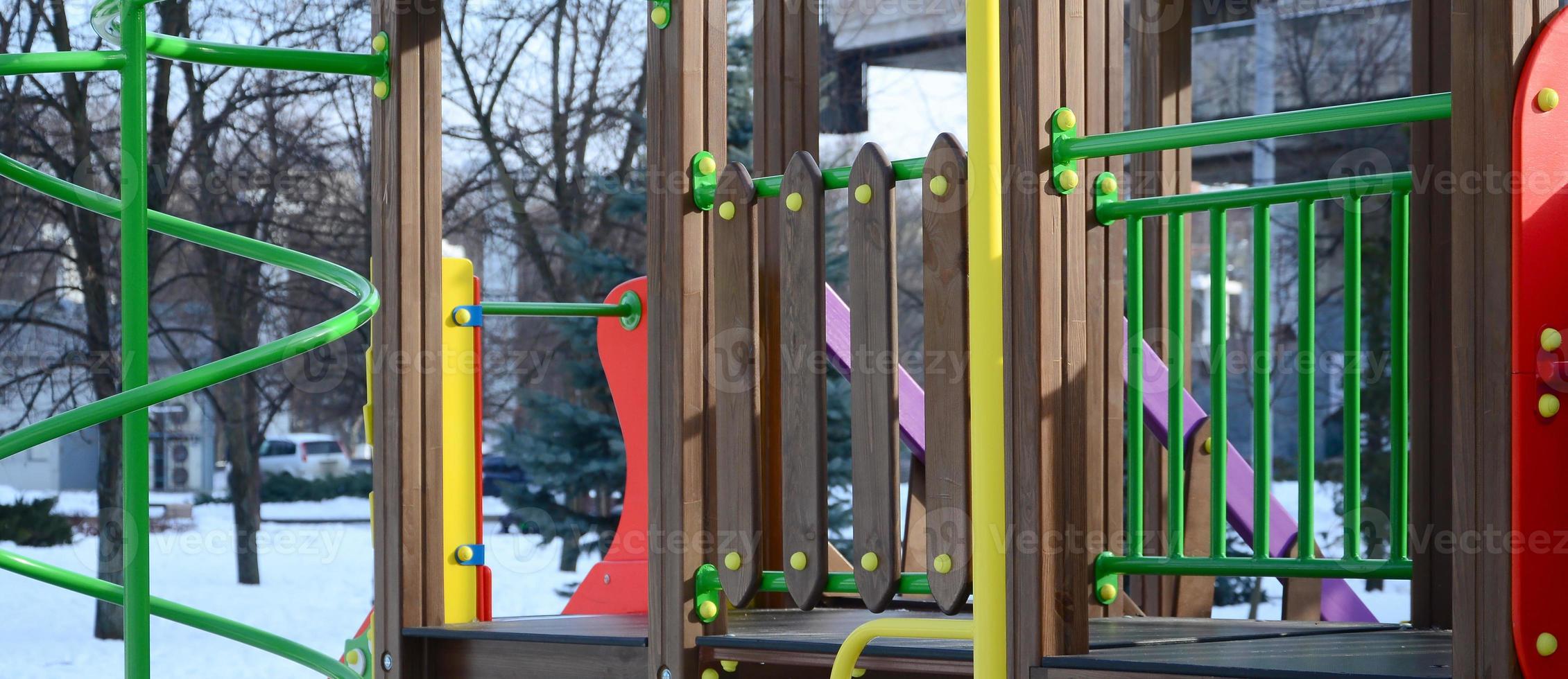 Fragment of a playground made of plastic and wood, painted in different colors photo