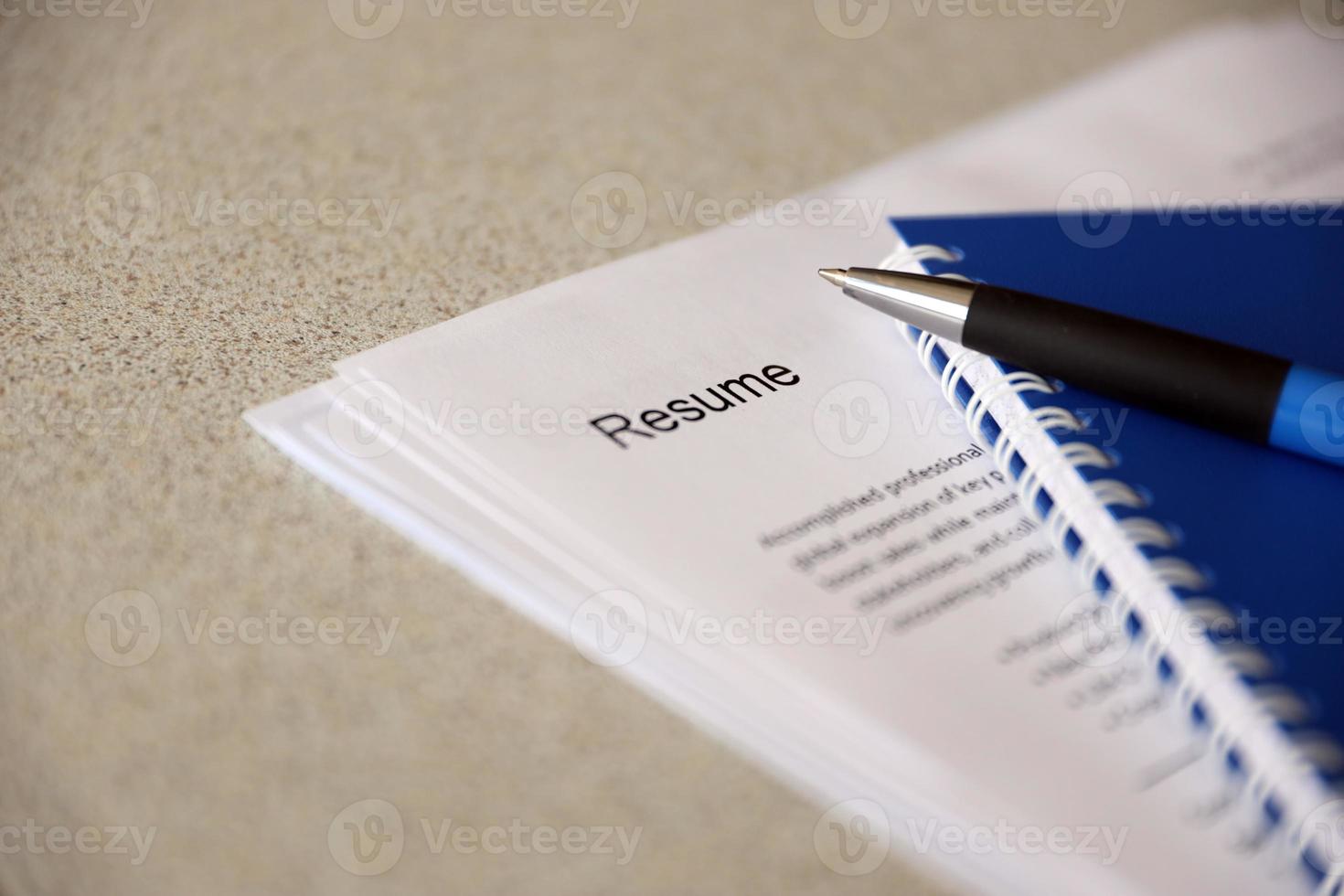 Top view of stack of office documents including resume and cv forms on the desk close to pen and notepad. Job seeking process. Hunting for workplace photo