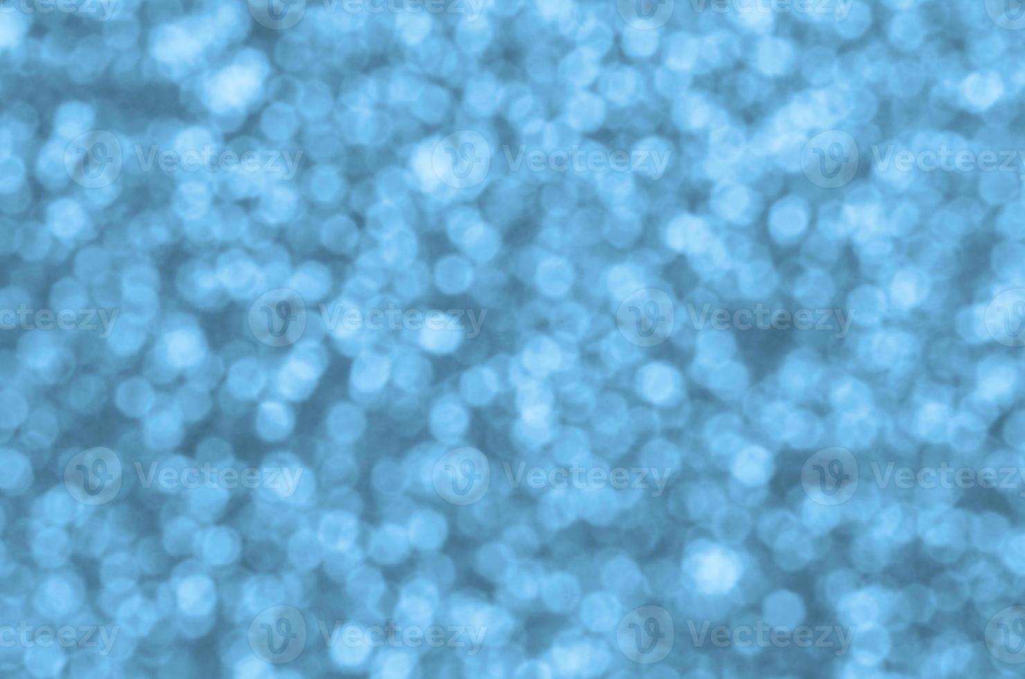 Blurred blue decorative sequins. Background image with shiny bokeh lights from small elements photo