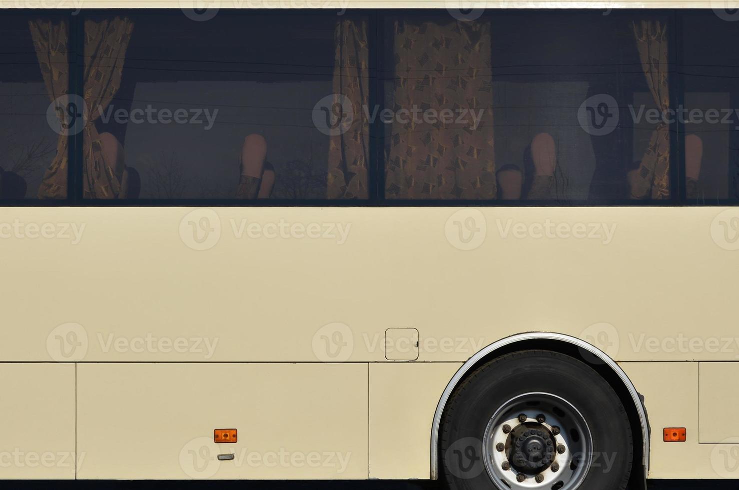 Photo of the hull of a large and long yellow bus with free space for advertising. Close-up side view of a passenger vehicle for transportation and tourism