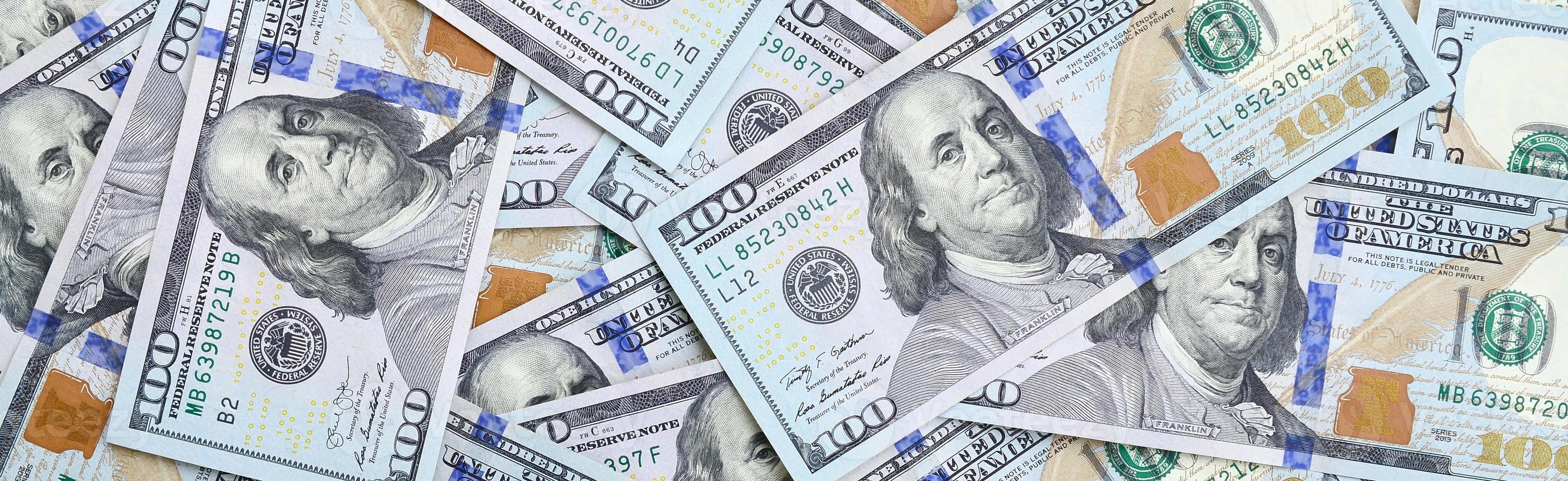 un gran número de billetes de dólares estadounidenses de un nuevo diseño con una franja azul en el medio. vista superior foto