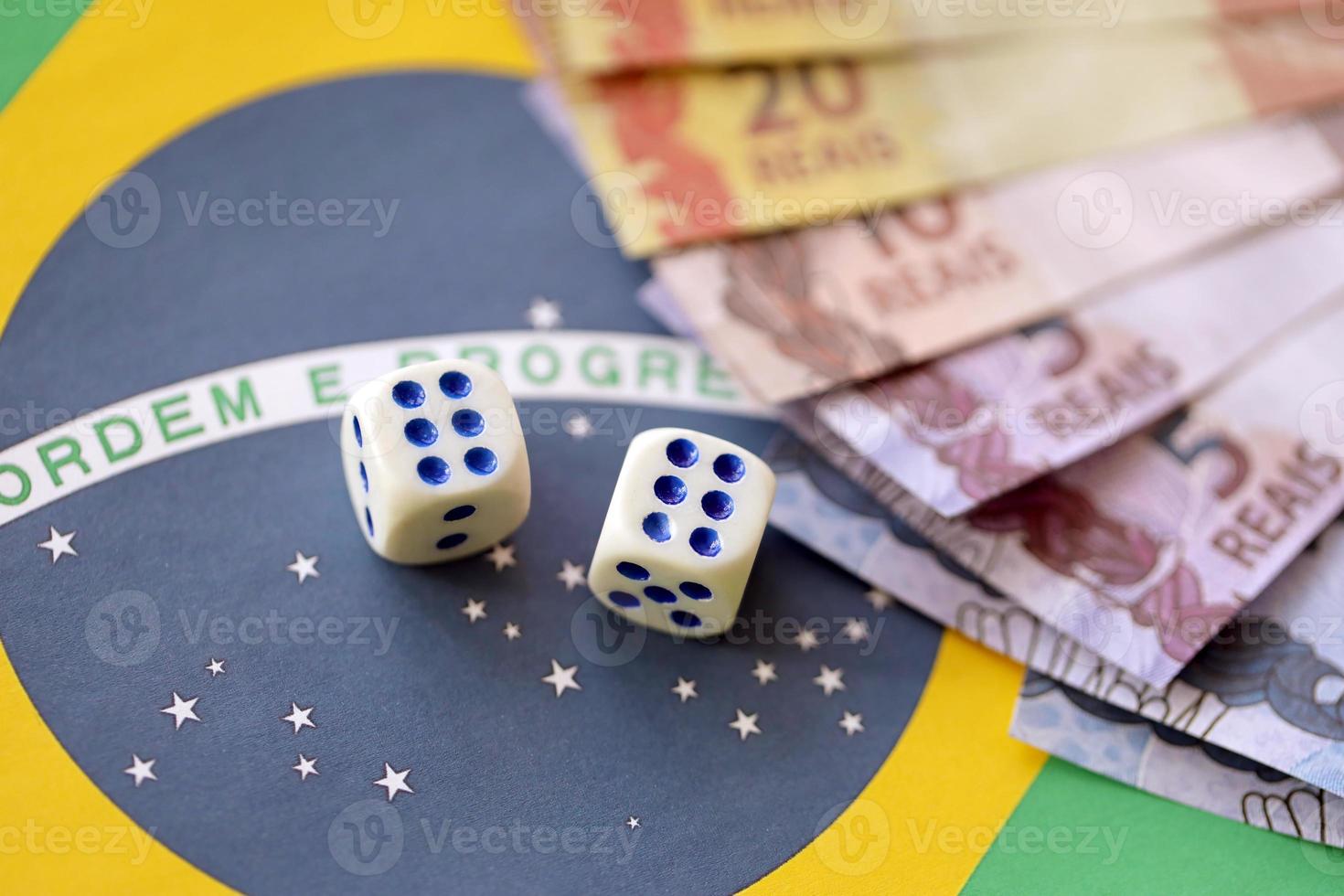 cubos de dados con billetes de dinero brasileño en la bandera de la república de brasil. concepto de suerte y juego en brasil foto