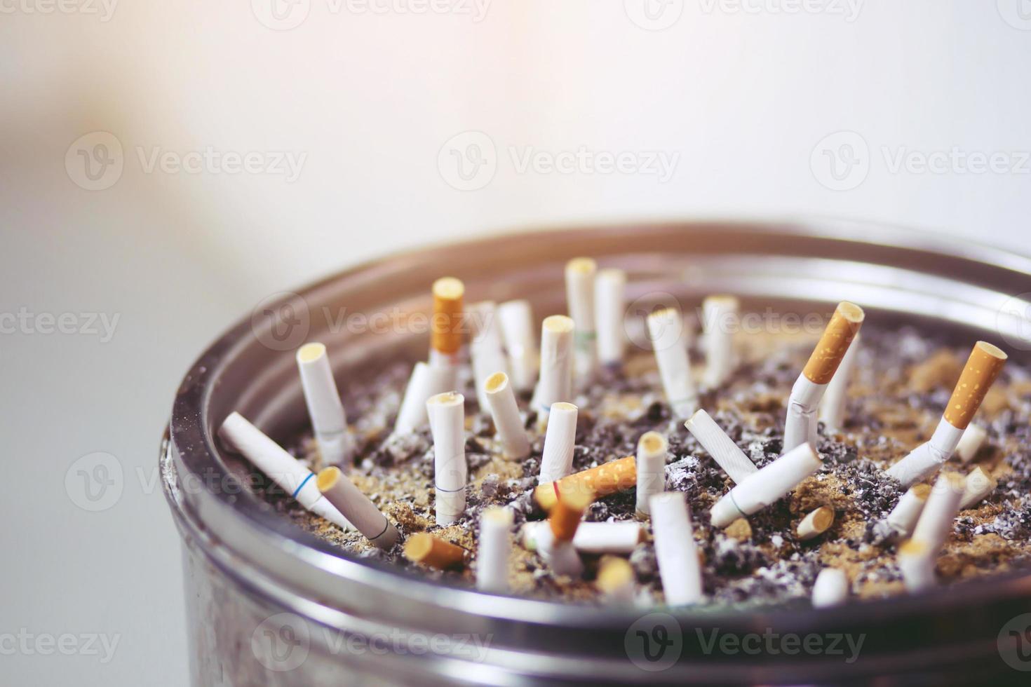 butt on cigarettes in the ashtray. There are many types of cigarette stub on the sand in the ashtray. A cigarette is not good for health. photo