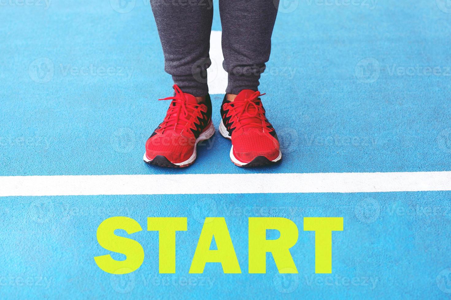 Start on athletics male jogging on the starting line on an asphalt of a stadium track preparing for a running track. photo