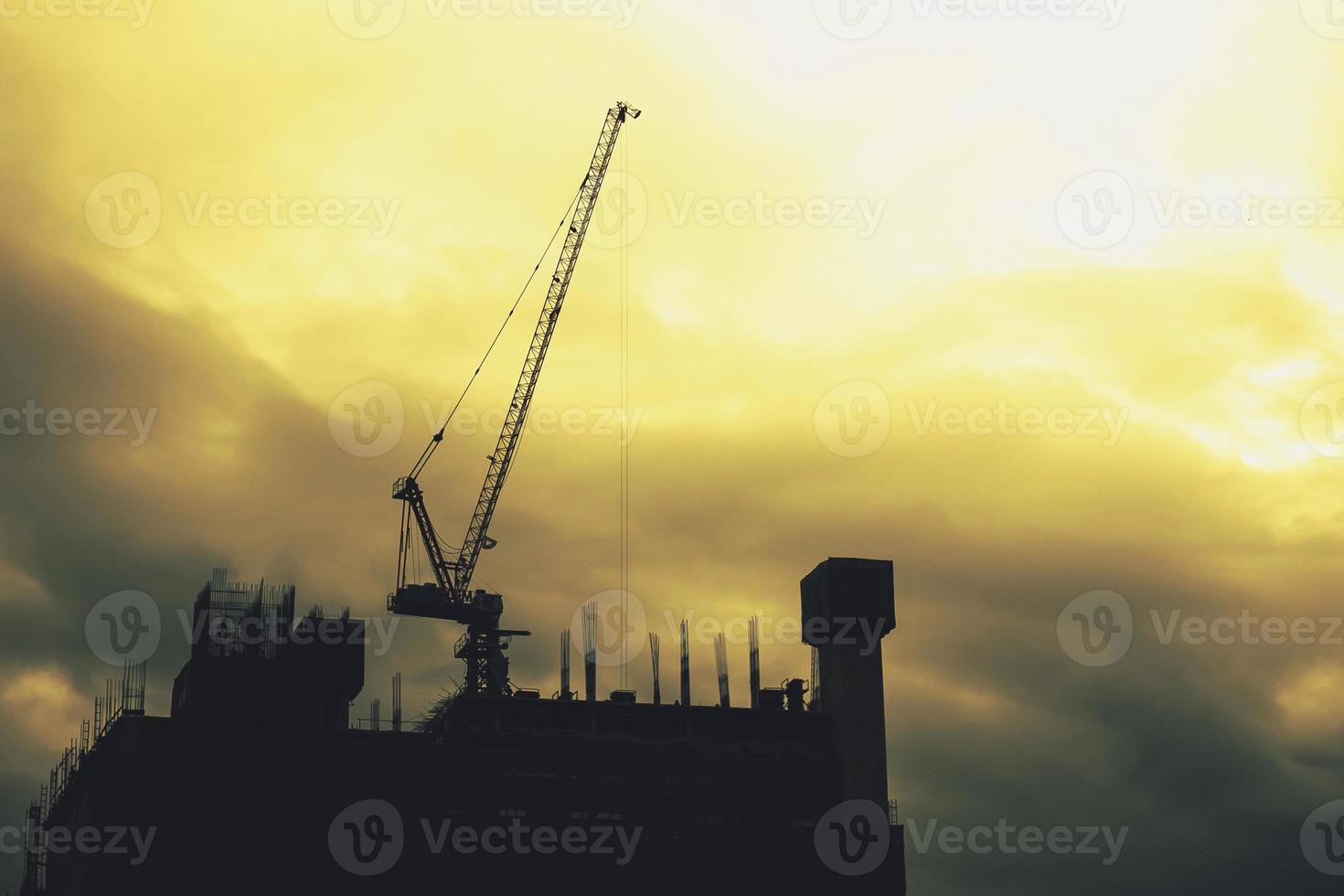 The tower crane is lifting things at the construction site. photo