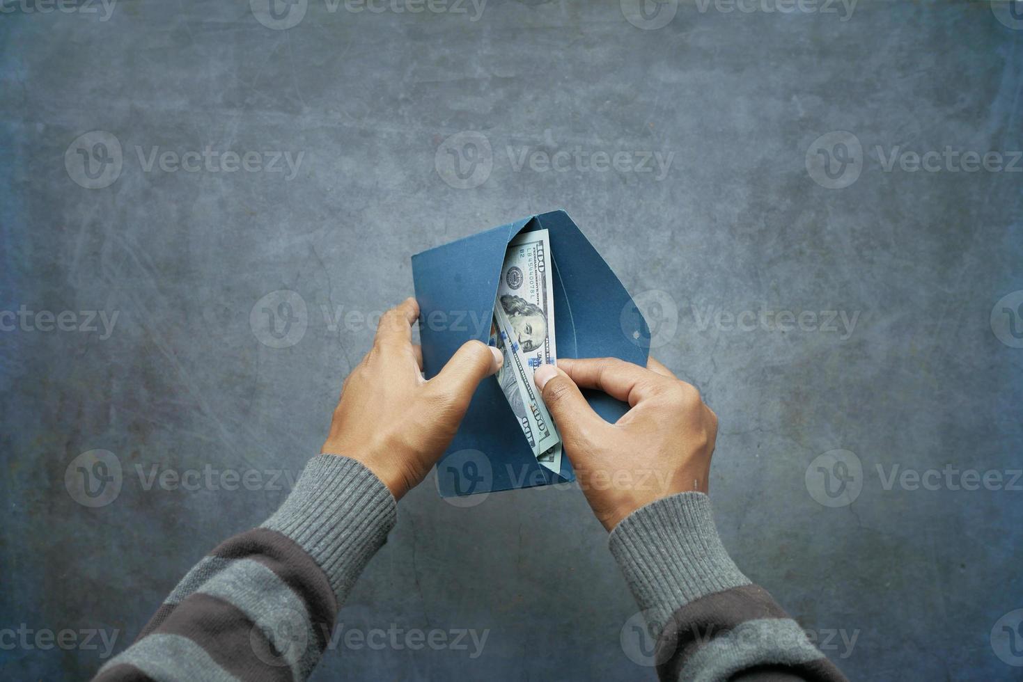 person hand putting cash in a envelope. photo