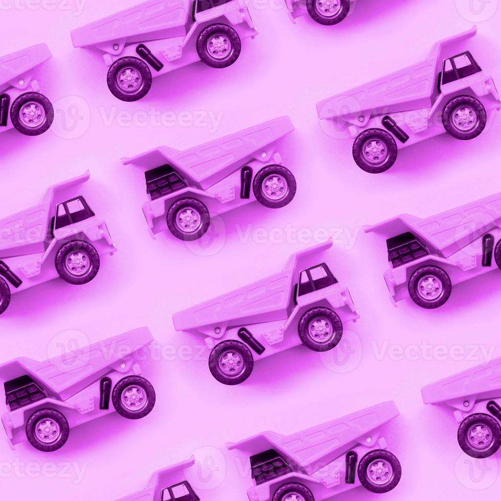 muchos pequeños camiones de juguete púrpura sobre fondo de textura de papel de color púrpura pastel de moda foto