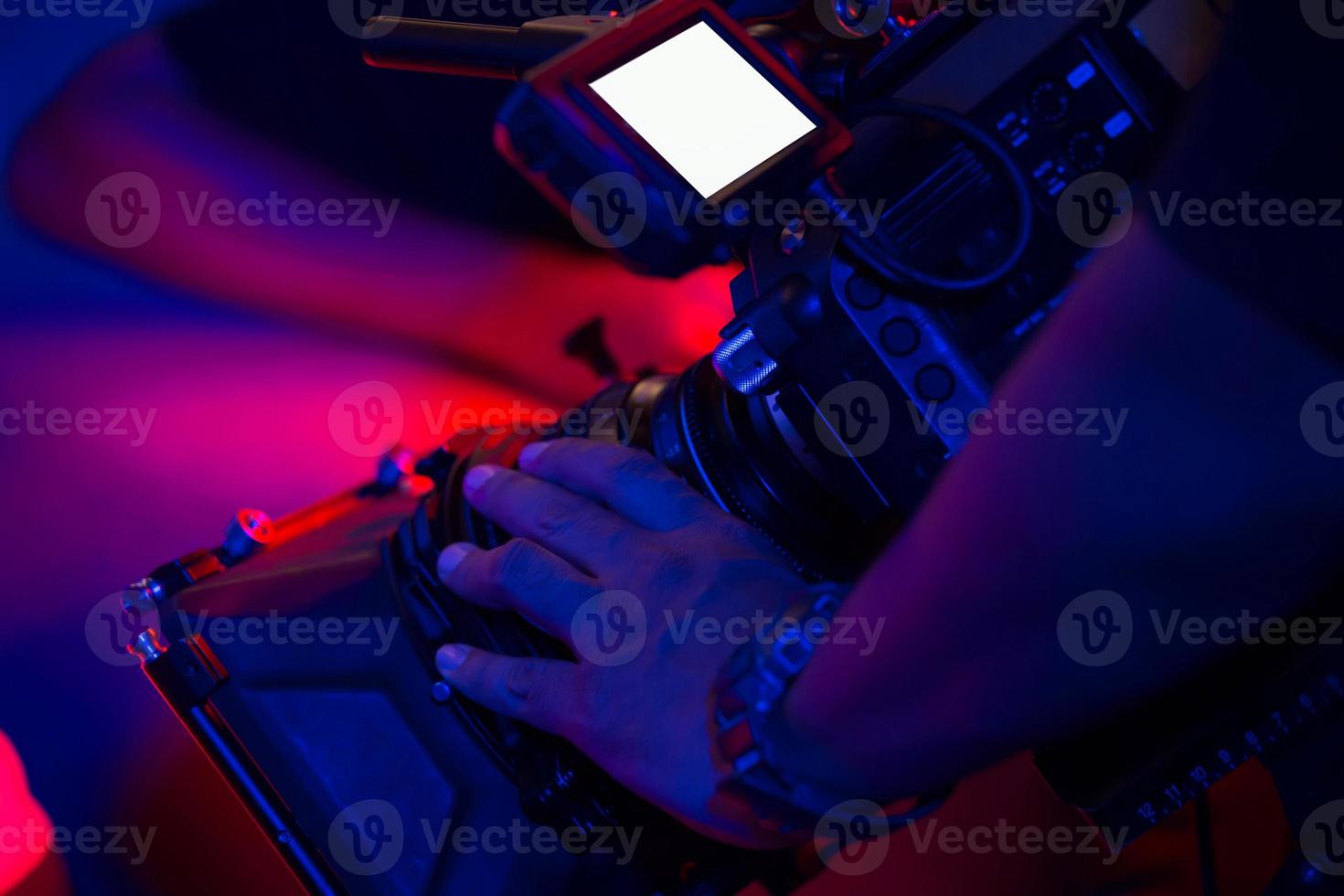 primer plano mano camarógrafo con cámara en vista panorámica grabación o filmación. en la iluminación de la ubicación, el concepto de pantalla blanca y colorida deja espacio para editar insertos de escenas de video. foto