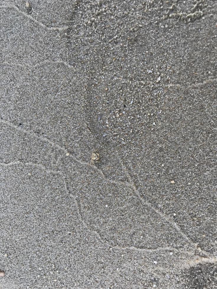 This is a picture of a background of sand on the beach that has just been washed away by the waves photo