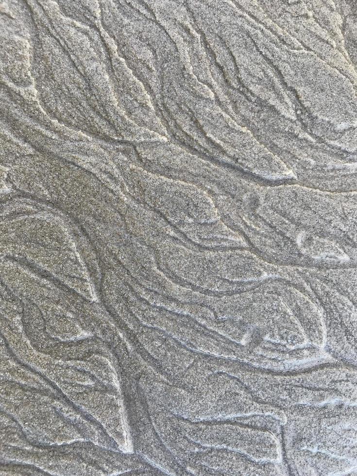 This is a picture of a background of sand on the beach that has just been washed away by the waves photo