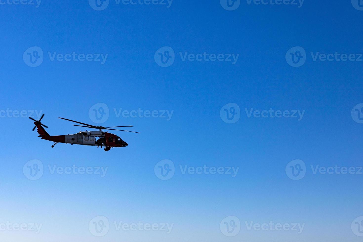 Military American helicopter flies in the blue sky. Military, rescue equipment. photo