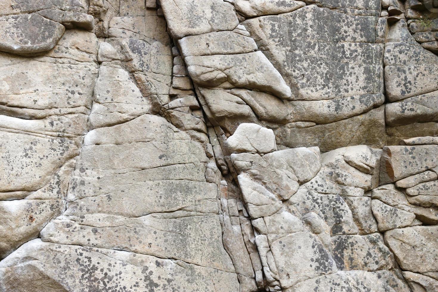 Light coarse natural rock stone background. Mining cliff rough front surface. Big limestone stack backdrop. Heavy grunge damaged granite block texture photo