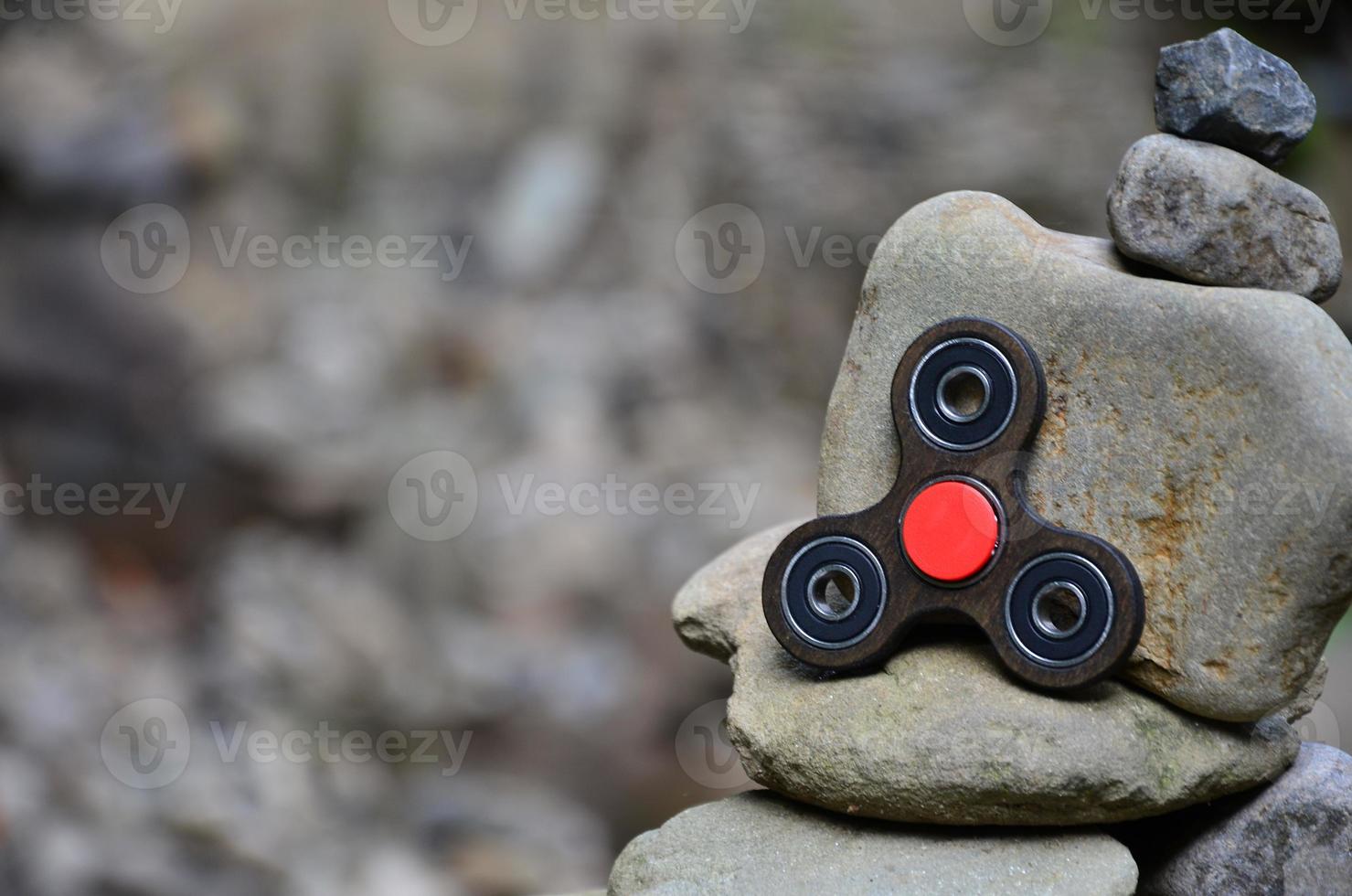 A wooden spinner lies on strange stone structures in the forest photo