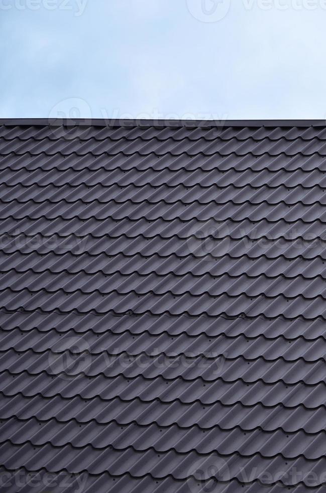 The texture of the roof of painted metal. Close-up detailed view of roof covering for pitched roof. High quality roofing photo