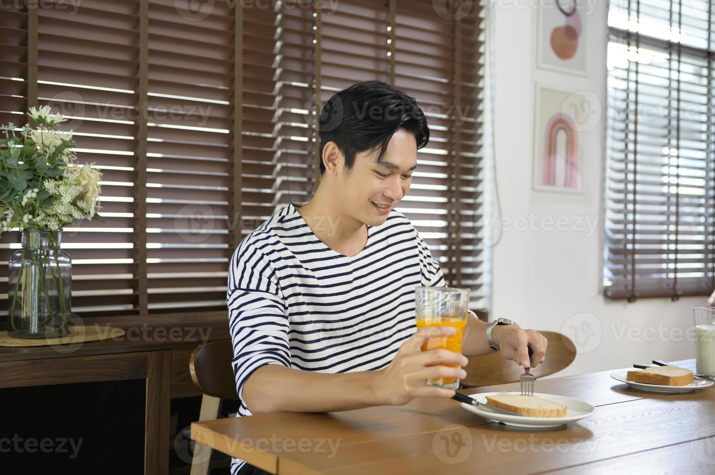 Young smiling asian man having meal on the table, family concept