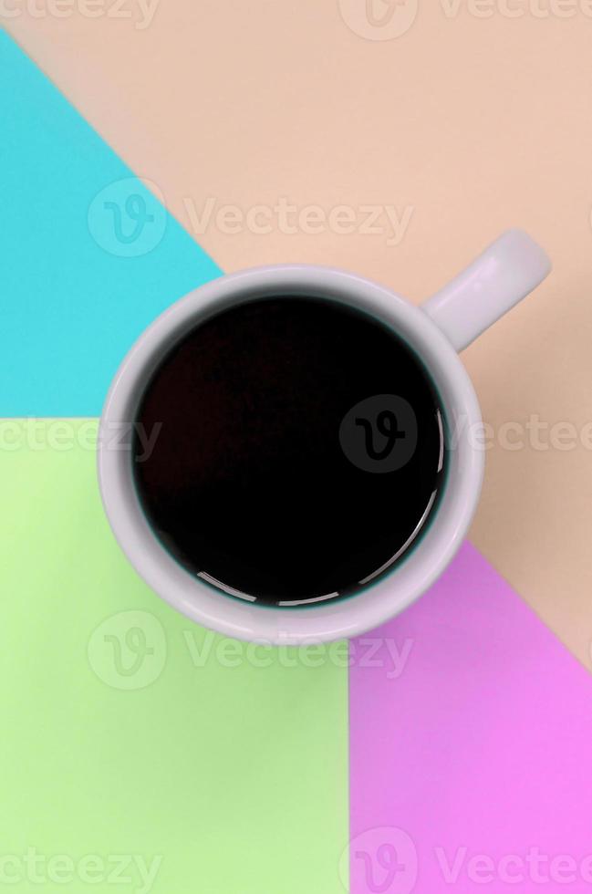 Small white coffee cup on texture background of fashion pastel pink, blue, coral and lime colors paper photo