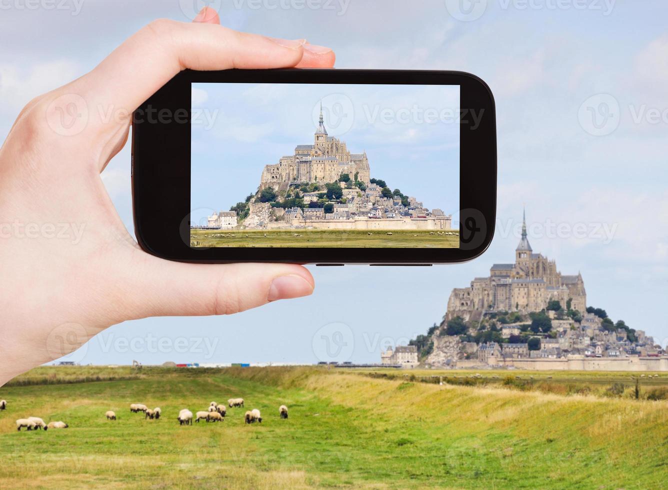 turista tomando fotos de la abadía de mont saint-michel