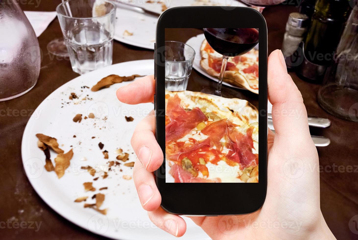 tourist photographs italian pizza with parma ham photo