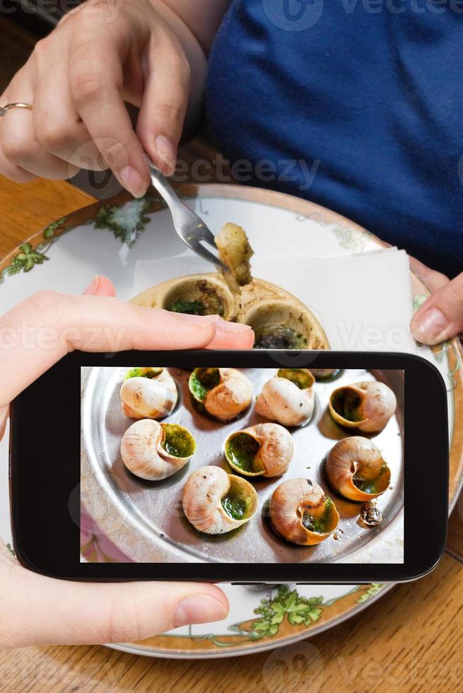 tourist photographs hot plate of escargot shells photo