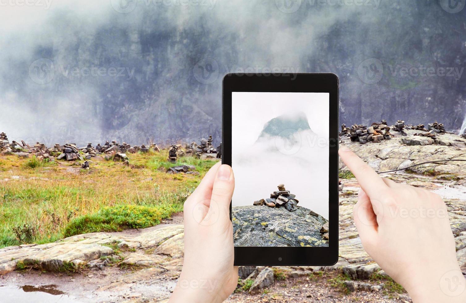 tourist taking photo of stone pyramid in Norway