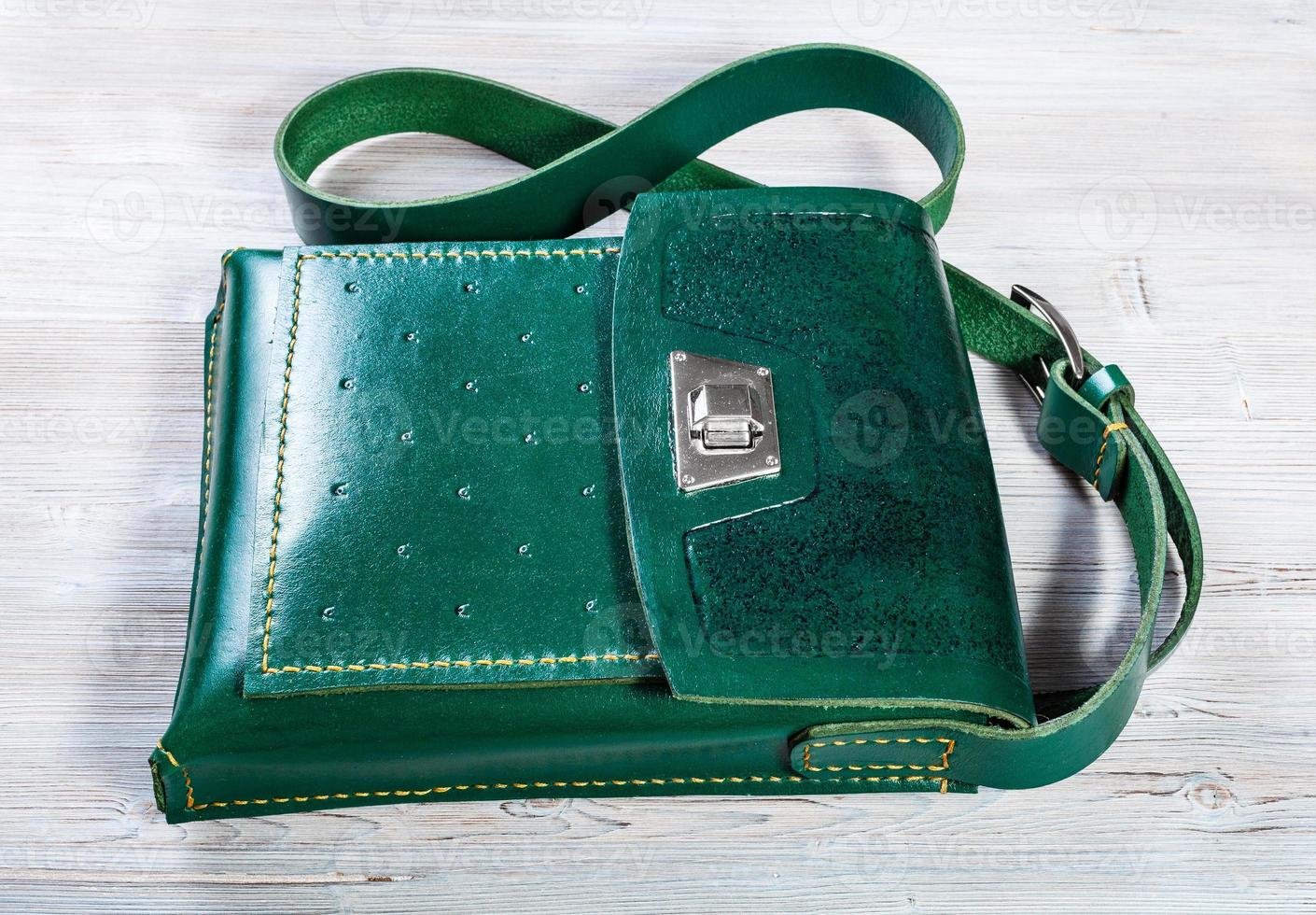 handcrafted green leather tablet bag on gray photo