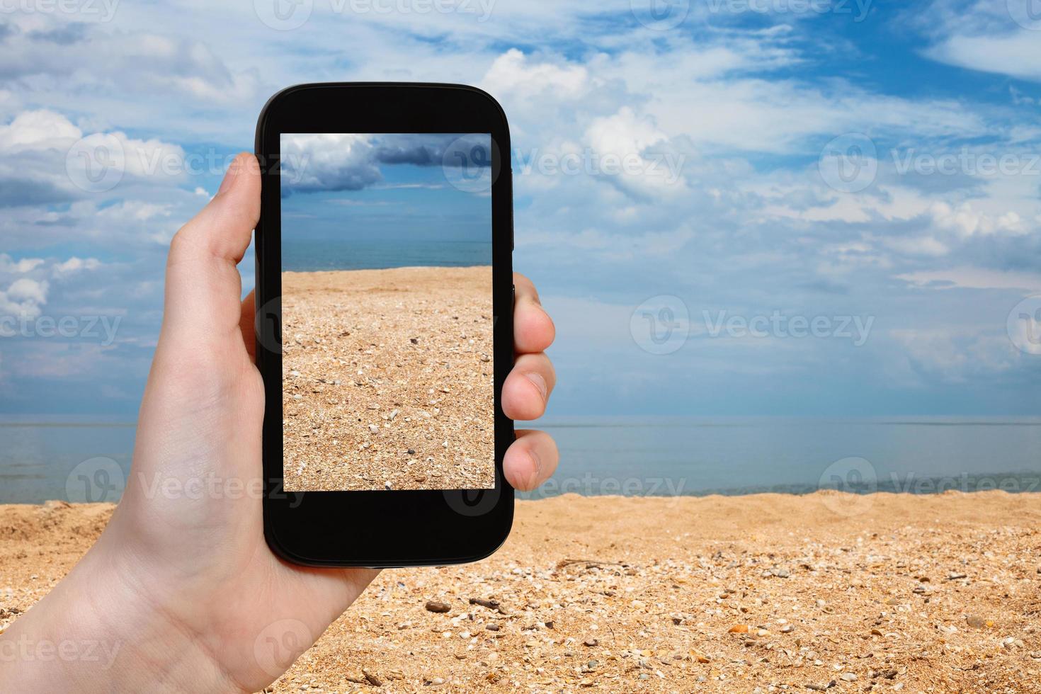 playa de conchas y arena del mar de azov en el teléfono inteligente foto