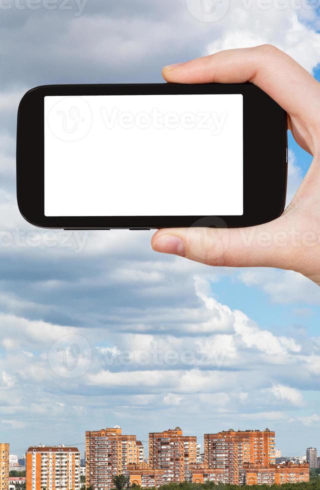 smartphone and cloudy sky over city photo