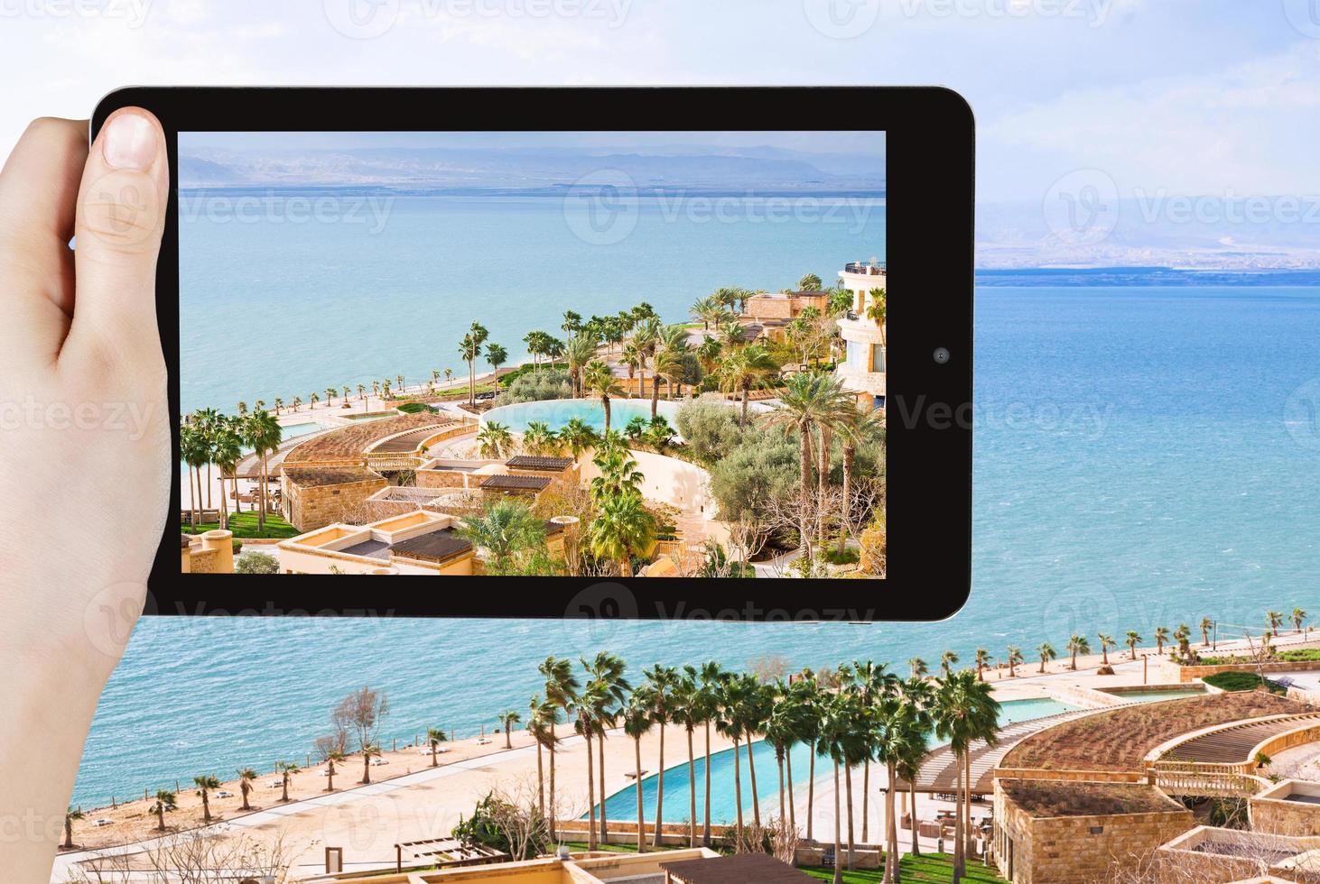 tourist taking photo of waterfront on Dead Sea