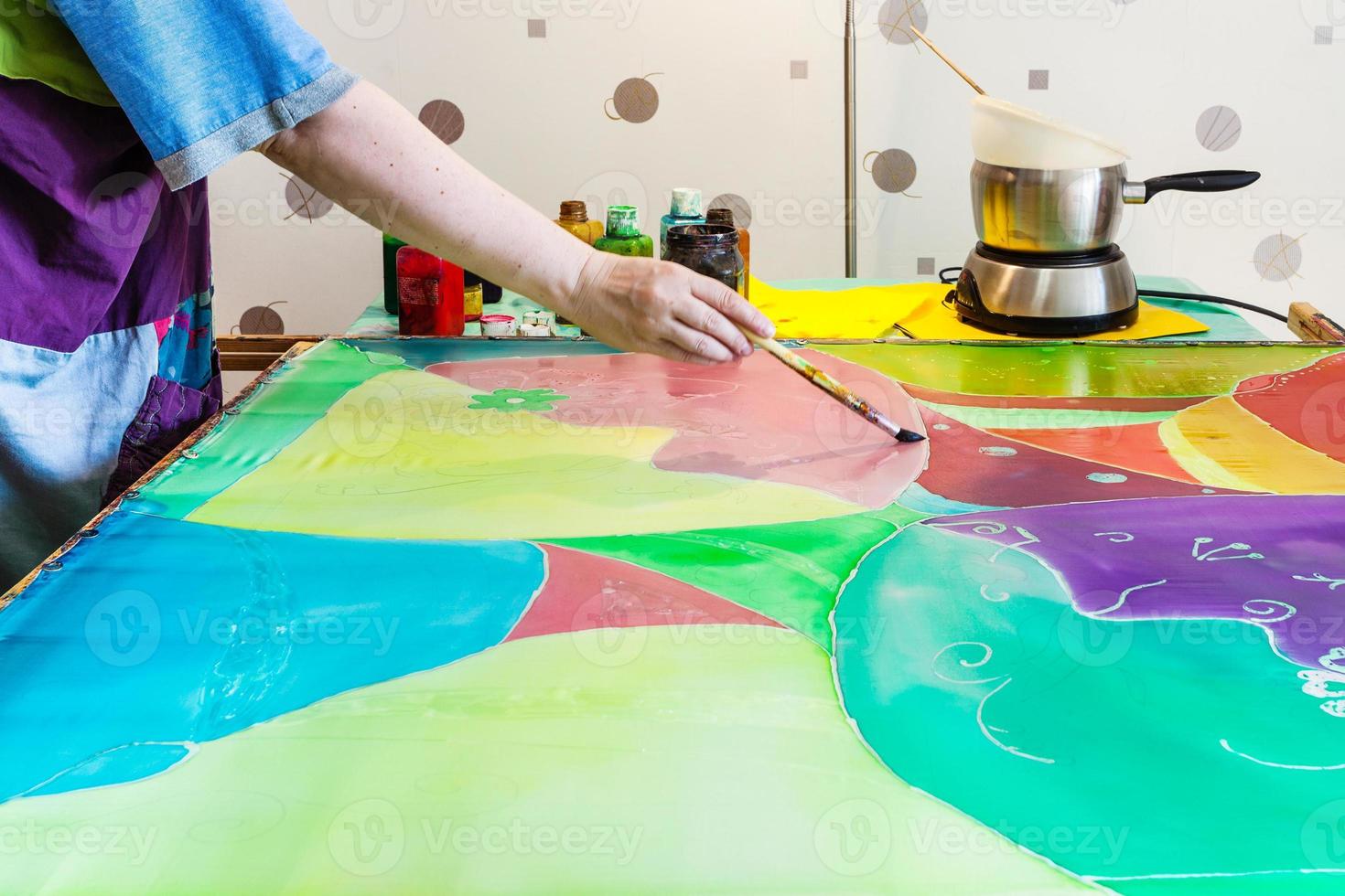 artist gets second layer of paint on silk fabric photo