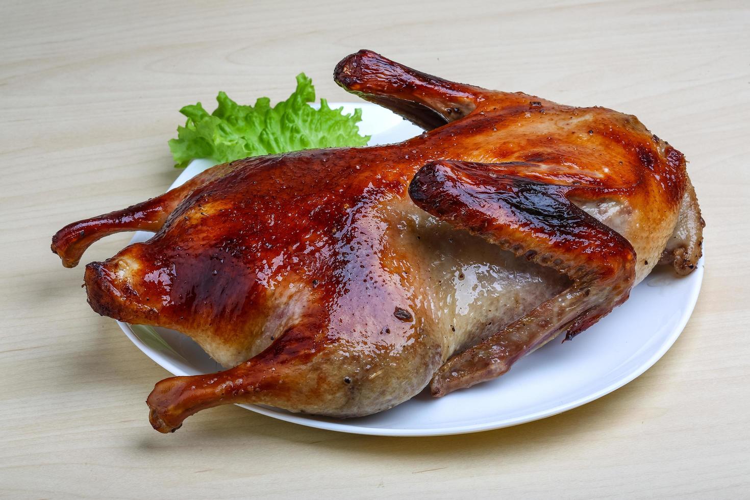 Roasted duck on the plate and wooden background photo