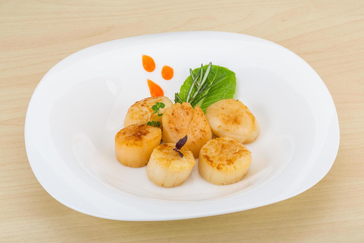 Grilled scallops on the plate and wooden background photo