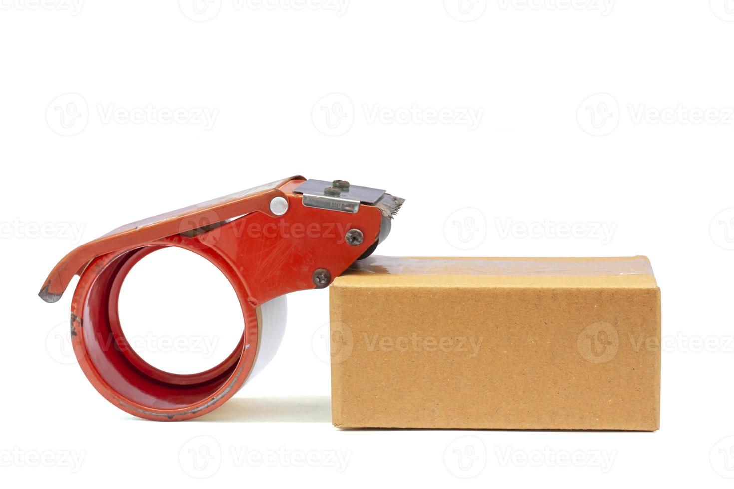 Roll of clear plastic packing tape on brown box isolated on white background. photo