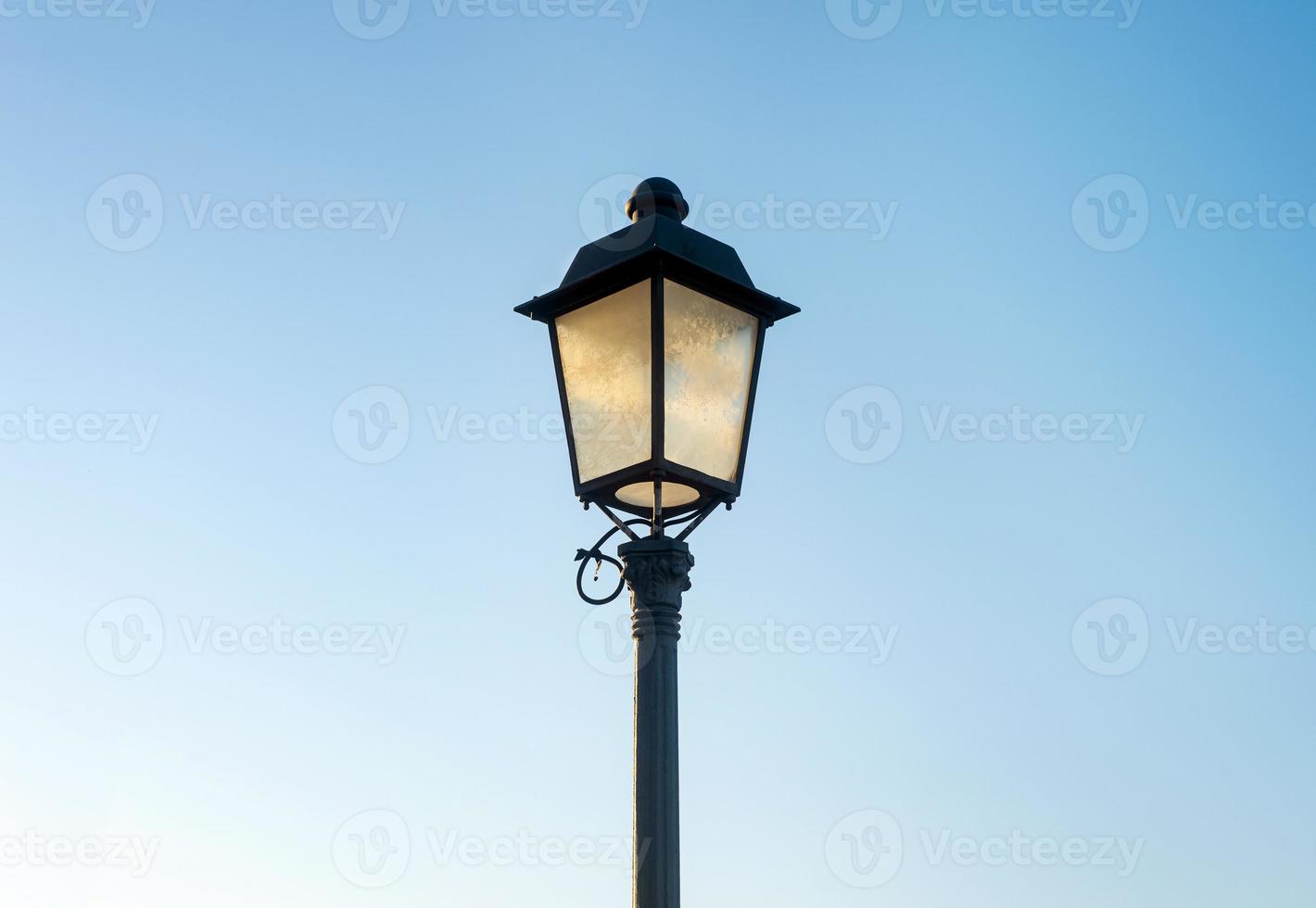 photo of an old styled street lamp against a clear blue sky
