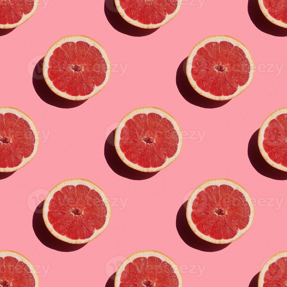 seamless pattern of fresh ripe grapefruit with a shadow on a pink background photo