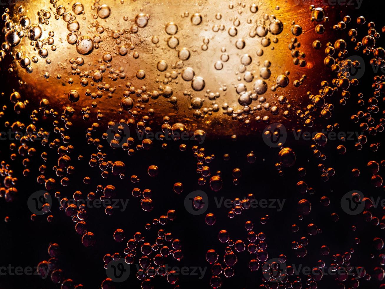 macro photo of the texture of bubbles in a glass of refreshing cold cola with ice