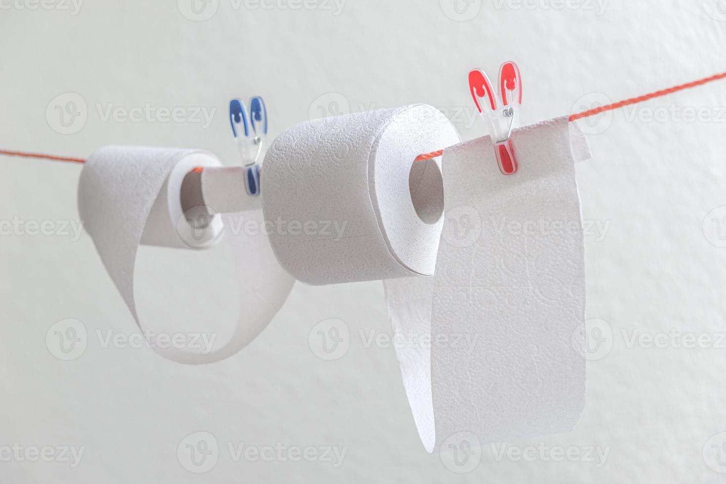 Toilet paper rolls hanging on clothesline for drying and reuse and washing. Concept of economical, financial crisis. Humorous anecdotic concept. photo
