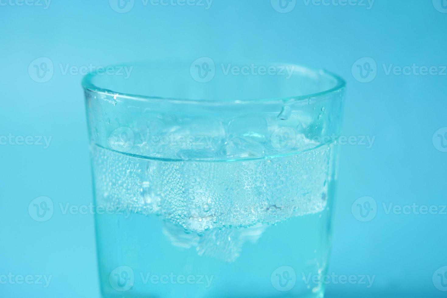 pouring soft drinks in a glass with ice cube photo